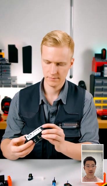 An engineer handling components during a live video conversation